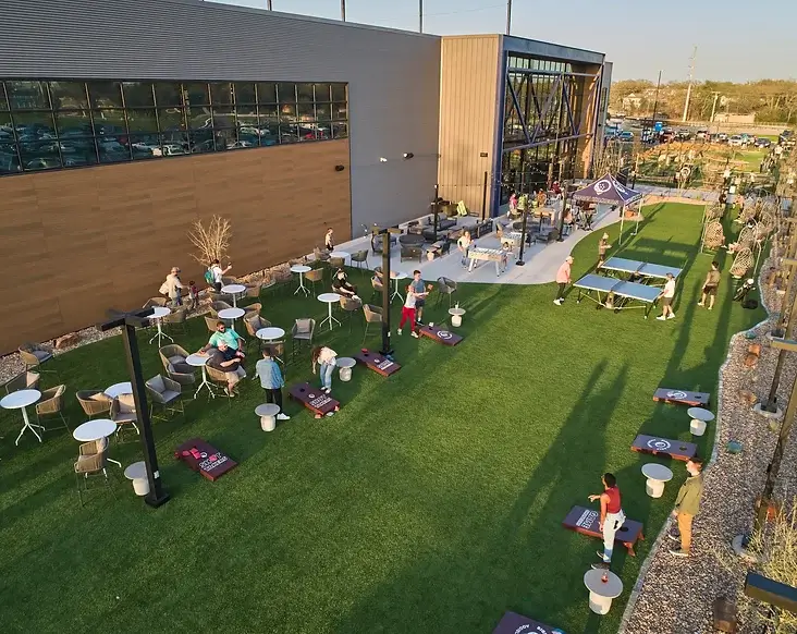 Outdoor patio in the yard with people enjoying ping pong and games.