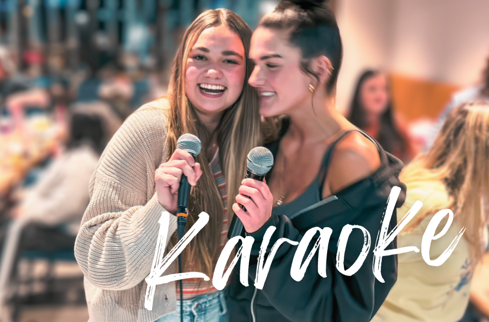 Two women smiling and holding microphones at Crush Golf and Grill, engaging with the camera.