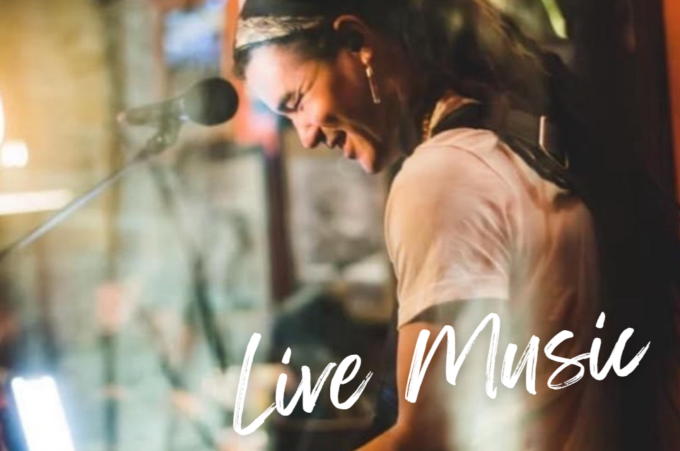 A man with dreadlocks plays a keyboard at Crush Golf and Grill, creating a lively atmosphere.